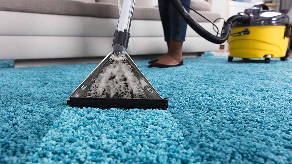 Reinigingsspecialist aan het werk op een tapijt in een woning in Utrecht